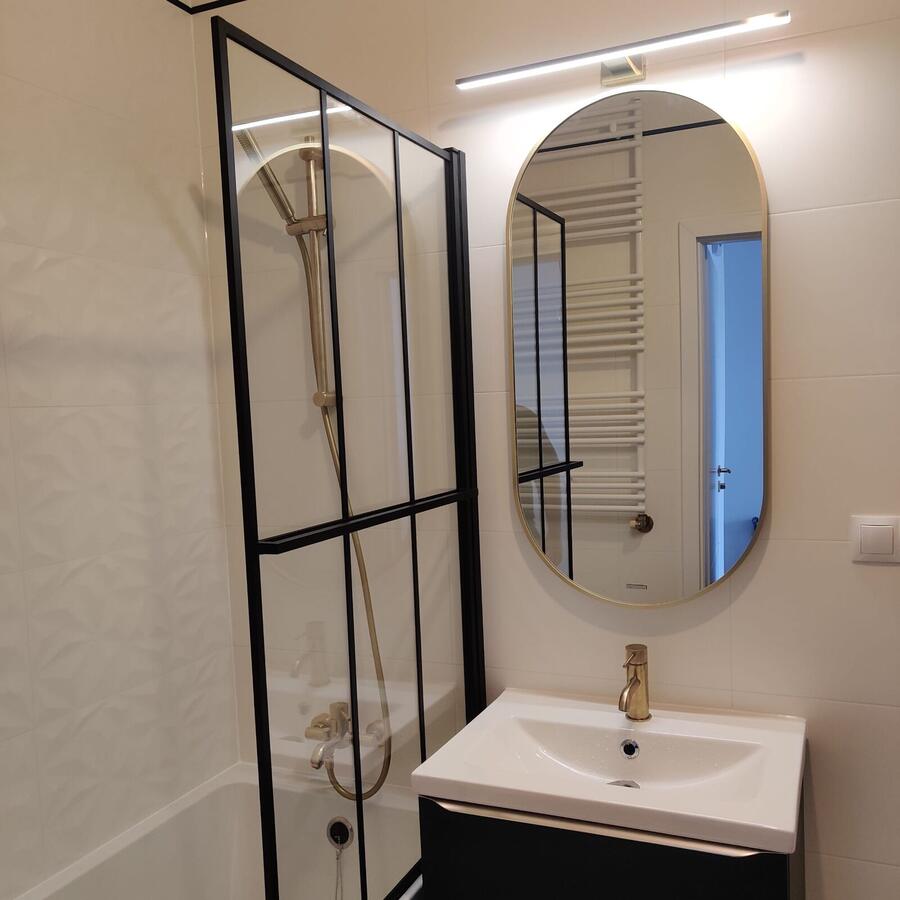 Łazienka z czarną kabiną w stylu loft i złotą armaturą