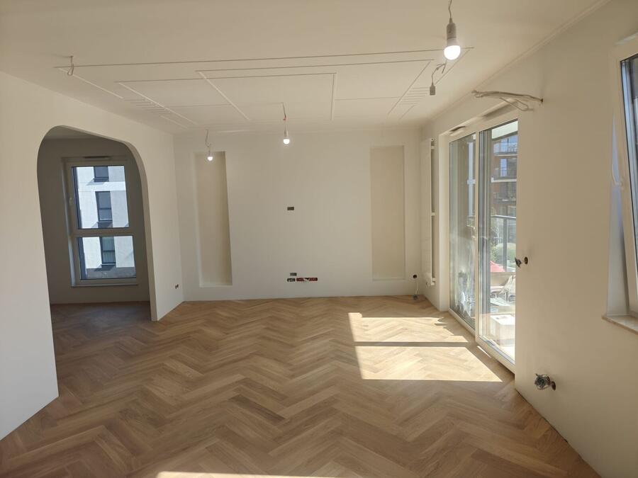 Salon z parkietem w jodełkę i łukowym przejściem